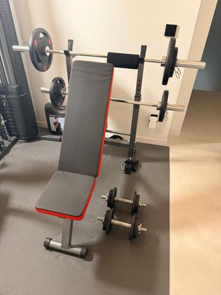 Banco de pesas con barras y mancuernas