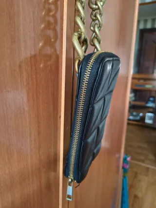 Bolso móvil negro con cadena dorada