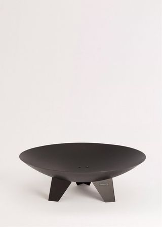 Brasero de metal negro con saco de leña