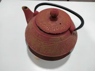 Tetera de hierro fundido roja y dorada más calenta