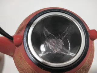 Tetera de hierro fundido roja y dorada más calenta