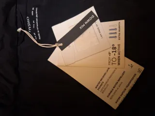 Chaqueta negra acolchada mujer joven es corta.