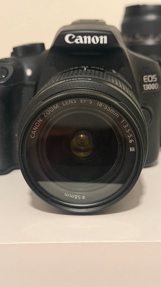 Cámara Canon EOS 1300D con cargador.