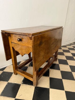 Mesa rústica de alas con cajones a los lados.