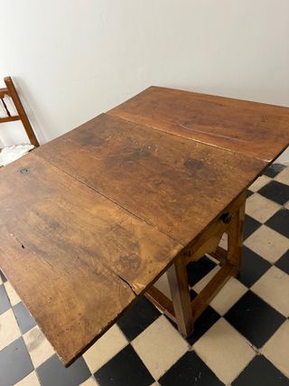 Mesa rústica de alas con cajones a los lados.