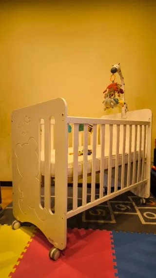 Cuna de madera con colchón y móvil