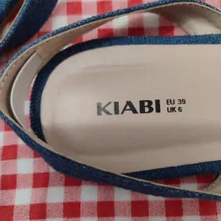 Sandalias planas azules bordadas con flores.