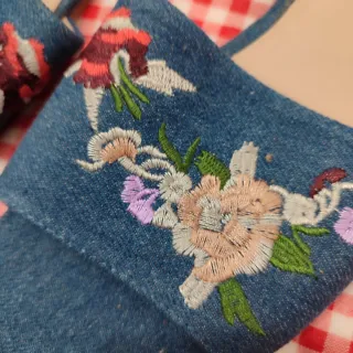 Sandalias planas azules bordadas con flores.