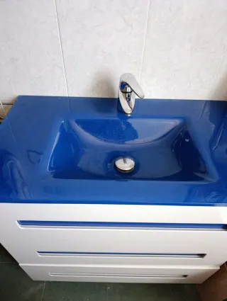 Mueble de baño con lavabo azul y espejo