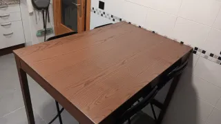 Mesa alta marrón con 4 taburetes negros plegables