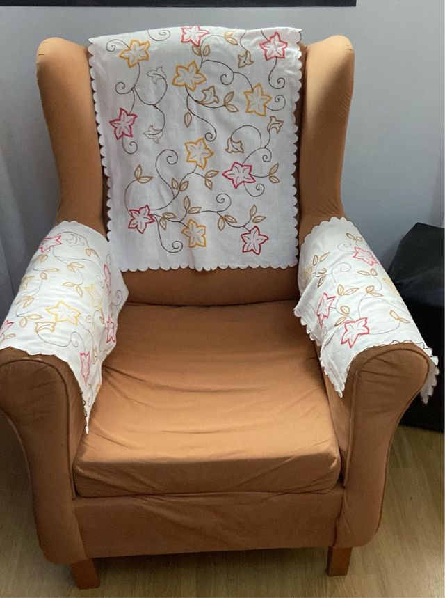 Sillón de tela marrón con tapetes