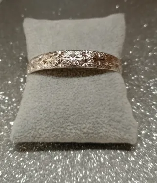 Pulsera rígida plateada con diseño floral