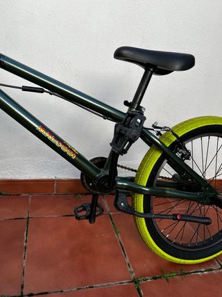 Bicicleta BMX verde con ruedas amarillas