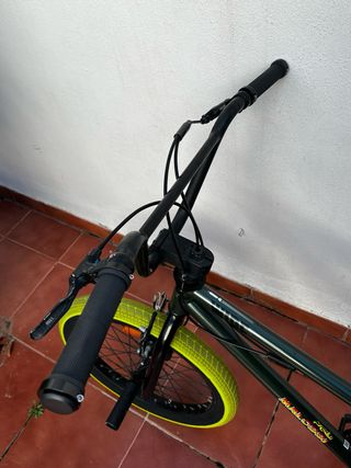 Bicicleta BMX verde con ruedas amarillas