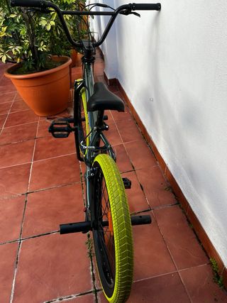 Bicicleta BMX verde con ruedas amarillas