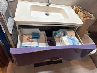 Mueble de baño morado con lavabo y grifo