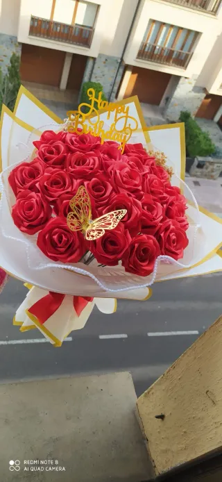 Ramo de rosas rojas y mariposa dorada