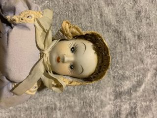 Bambola in porcellana con cappellino