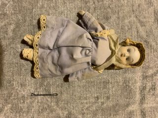 Bambola in porcellana con cappellino