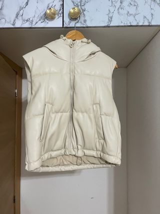 Chaleco acolchado beige con capucha.