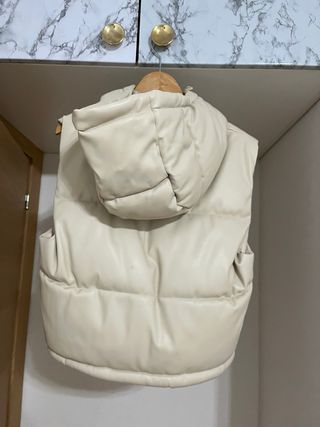 Chaleco acolchado beige con capucha.