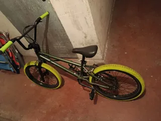 Bicicleta BMX verde con ruedas amarillas