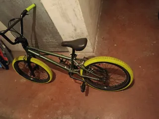 Bicicleta BMX verde con ruedas amarillas