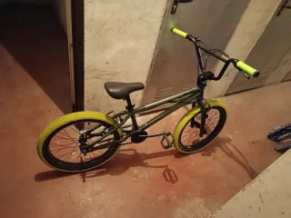 Bicicleta BMX verde con ruedas amarillas