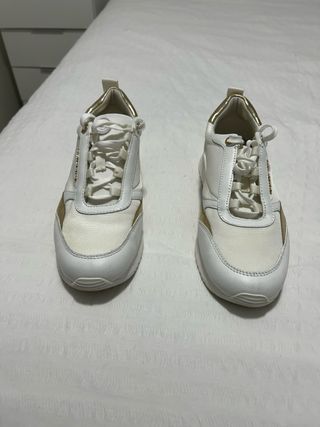 Zapatillas deportivas blancas y doradas