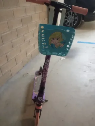 Patinete morado con cesta azul