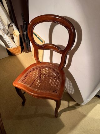 Escritorio de madera con silla de ratán y lampara