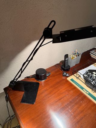 Escritorio de madera con silla de ratán y lampara