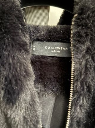 Casaco de pelo preto com fecho