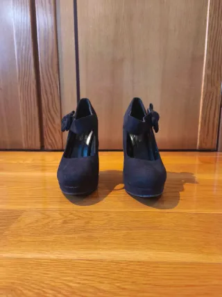 Zapatos de tacón negros con lazo.