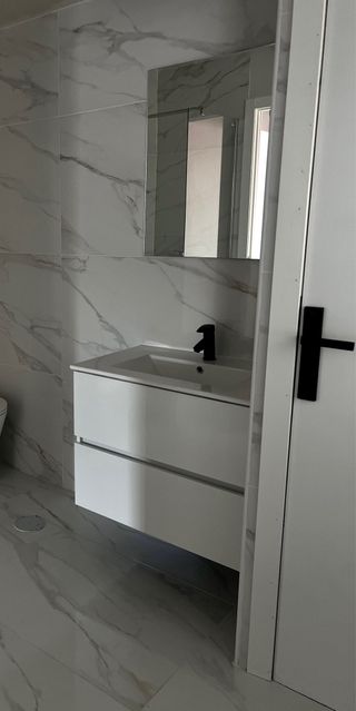 Lavabo de cerámica blanco con grifo negro