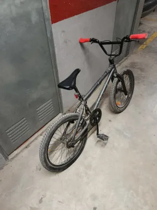 Bicicleta BMX gris con puños rojos