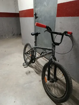 Bicicleta BMX gris con puños rojos
