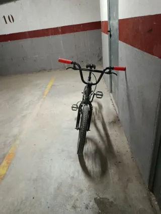 Bicicleta BMX gris con puños rojos