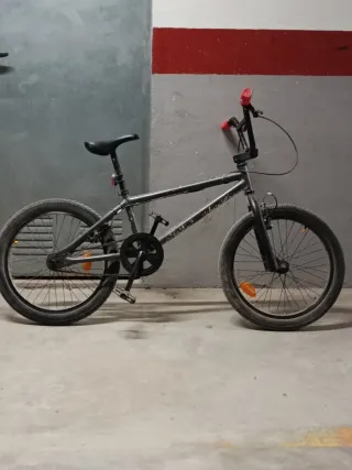 Bicicleta BMX gris con puños rojos