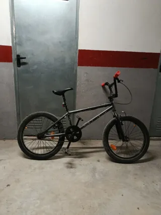 Bicicleta BMX gris con puños rojos