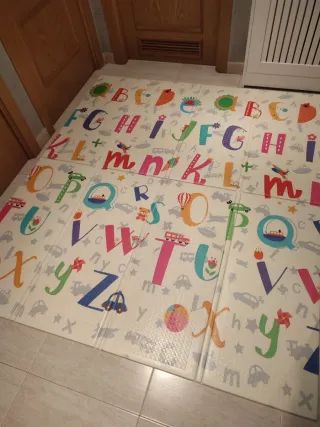 Alfombra infantil con letras y dibujos.