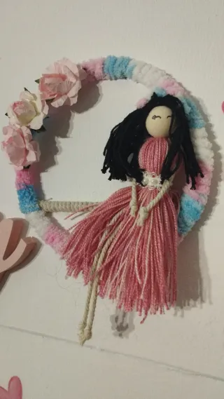 Muñeca de tela con flores y guirnalda