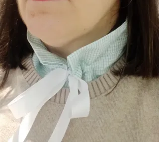 Collar de camisa con lazo blanco.