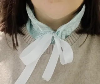 Collar de camisa con lazo blanco.