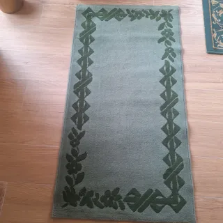 Tappeto verde con bordo floreale