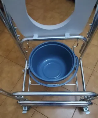 Silla de rueda de ducha con inodoro.