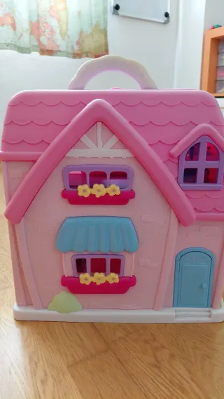 Casita de muñecas rosa con balcón