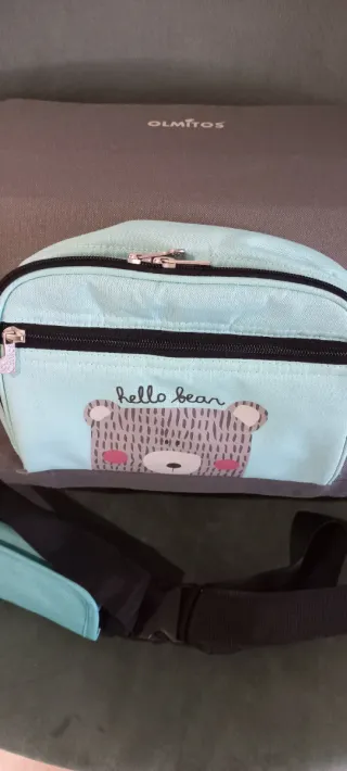 Trona de viaje gris y azul con dibujo de osito