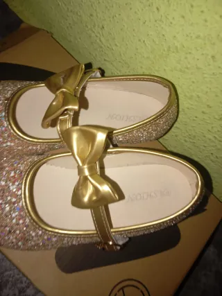 Zapatillas doradas con brillos y lazo