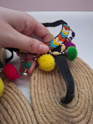 Sandalias con pompones y abalorios.